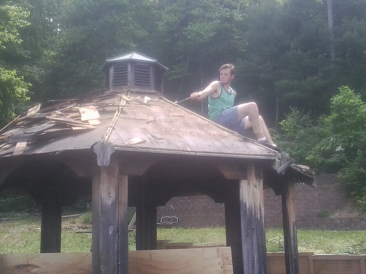 Tearing the old roof off a wooden gazebo before new shakes in Effingham
